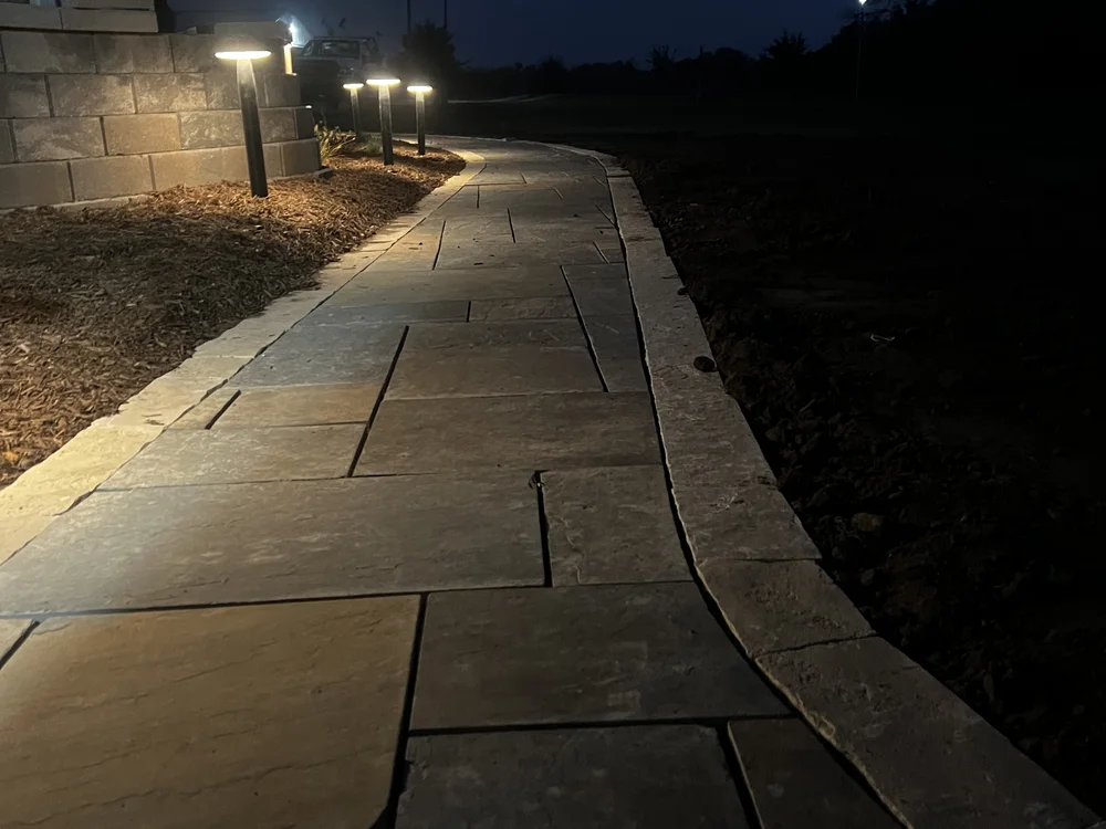 Lit flagstone walkway at night by Larkin Landscape and Design