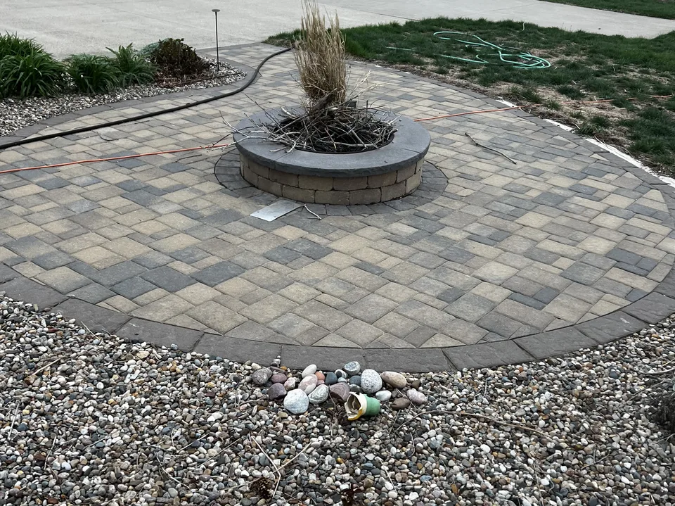 Circular paver patio built around a fire pit by Larkin Landscape and Design