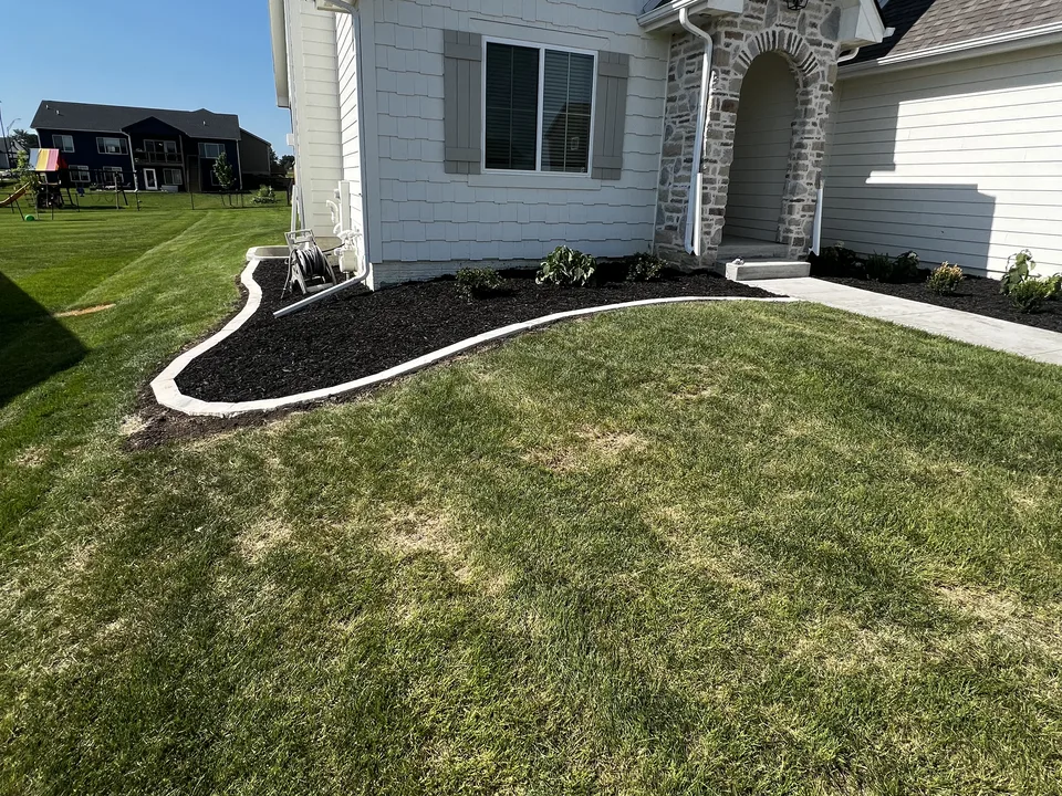Renovated planting bed with clean edging and mulch by Larkin Landscape and Design
