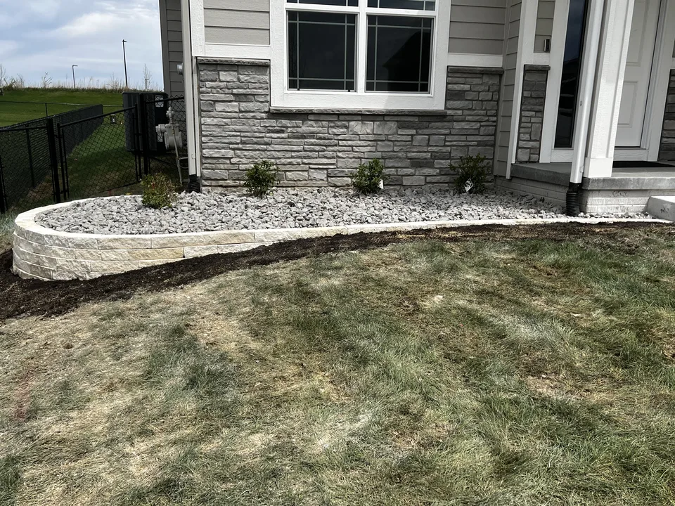 Boulder retaining wall holding a level terrace by Larkin Landscape and Design