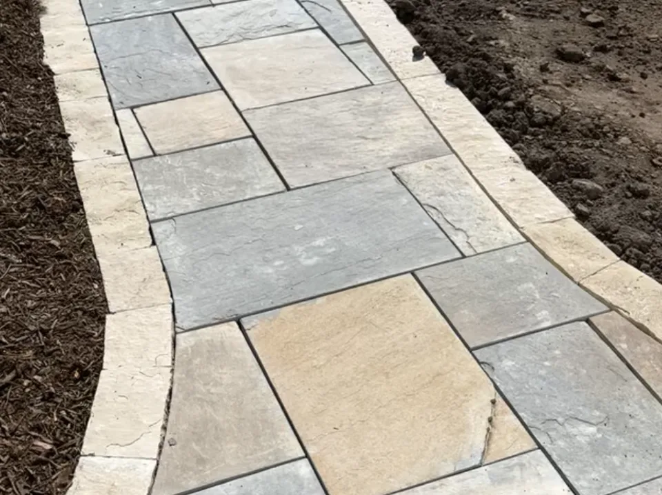Flagstone walkway leading through a planted yard by Larkin Landscape and Design