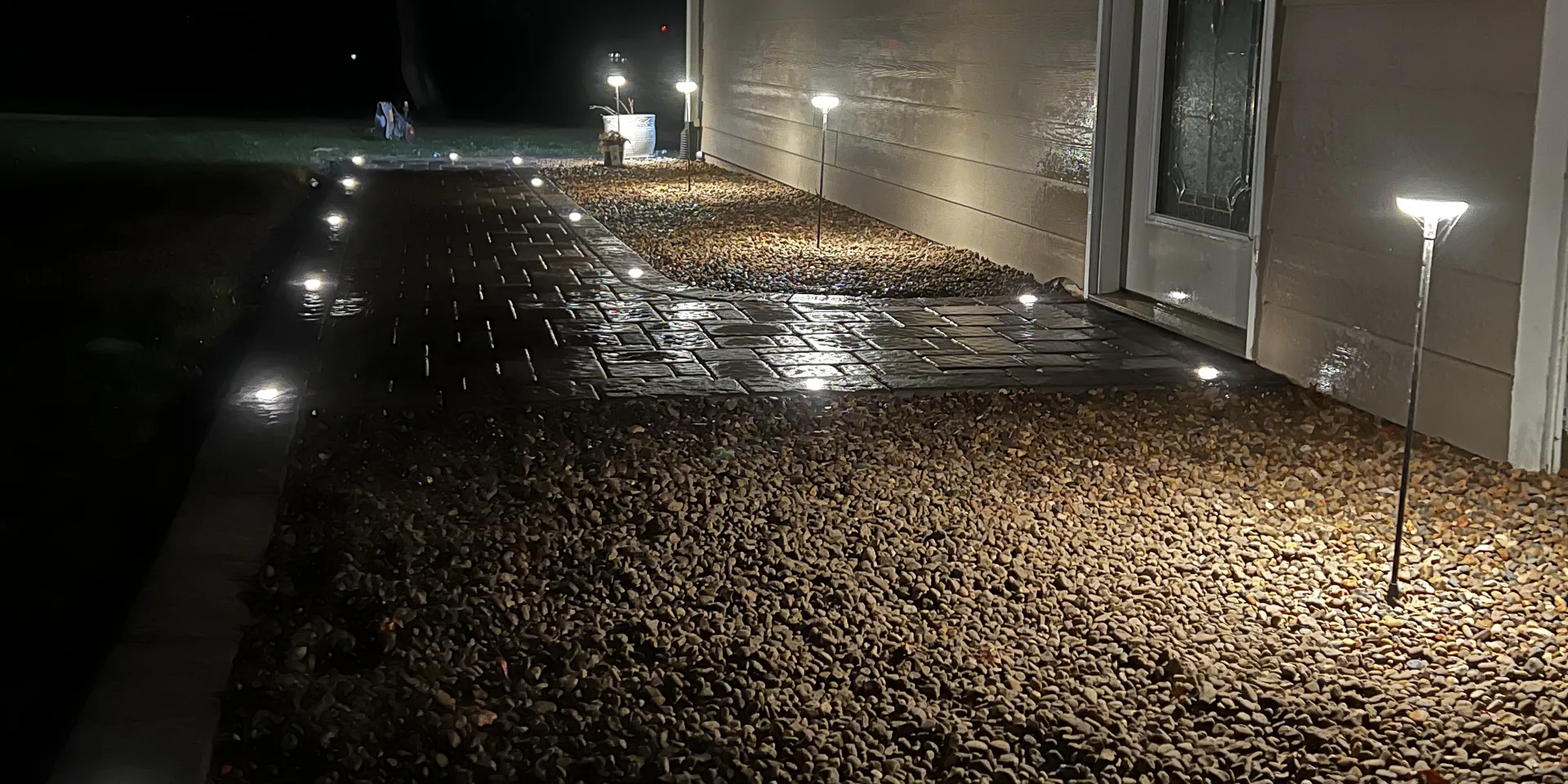 Planting beds lit at dusk with low-voltage landscape lighting by Larkin Landscape and Design