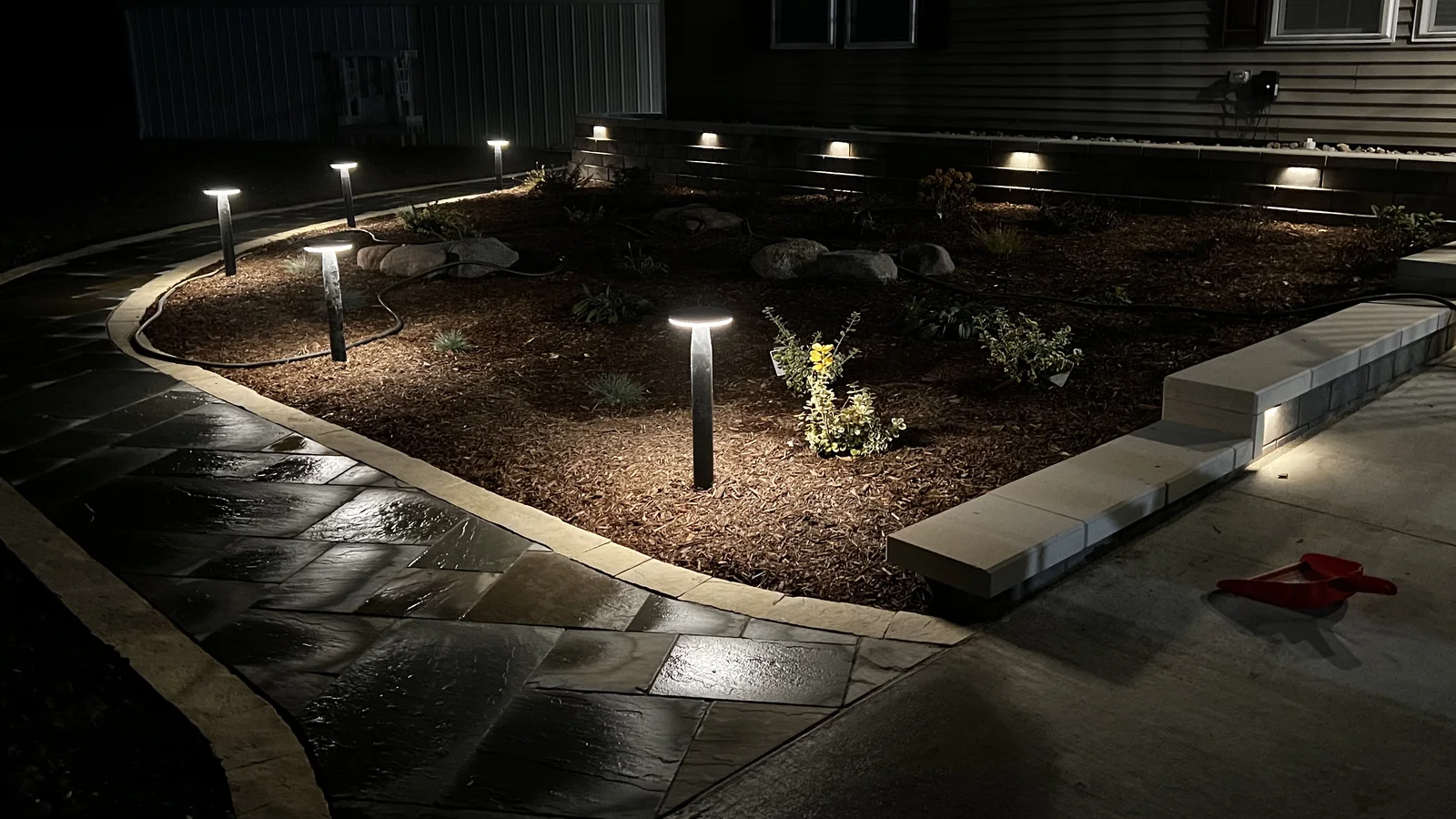 Stone walkway with a contrasting border between fresh planting beds by Larkin Landscape and Design