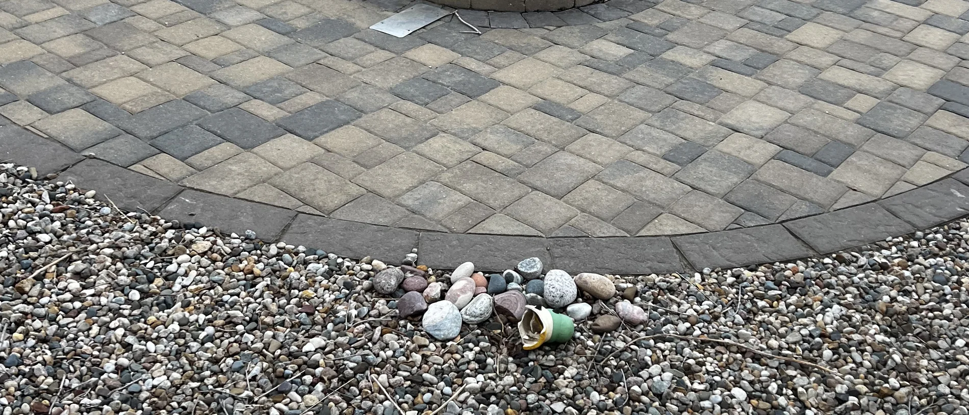 Fire pit set into a paver patio with seating around it, built by Larkin Landscape and Design