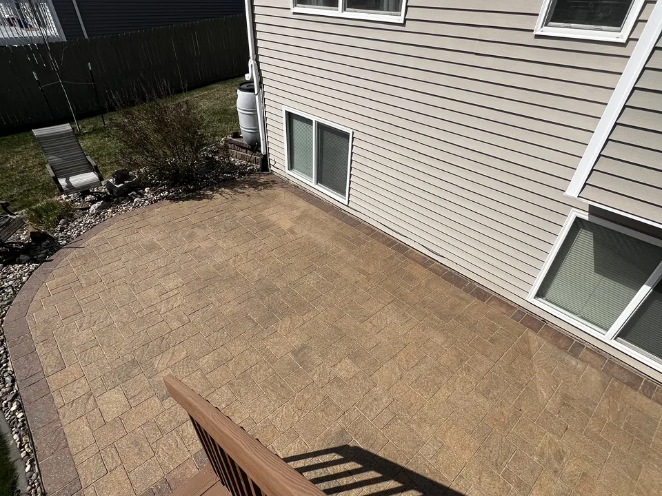 Paver patio beside a deck with a clean transition, built by Larkin Landscape and Design
